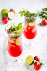 Pink lemonade with strawberries, lime, basil and mint