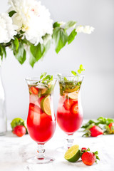 Pink lemonade with strawberries, lime, basil and mint