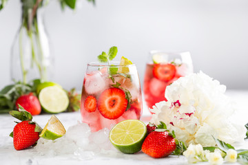 Pink lemonade with strawberries, lime, basil and mint