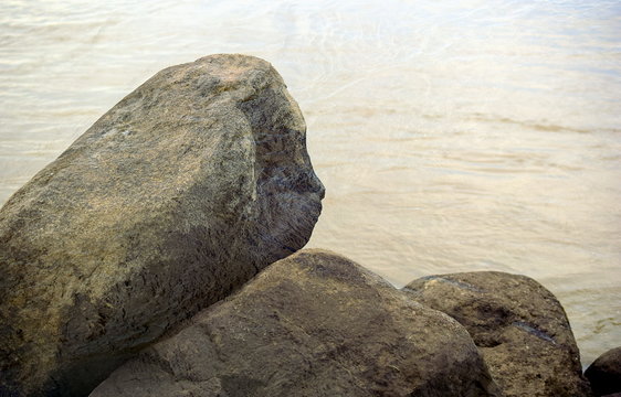 Basalt boulders. Huge stones on the background of calm water. Sikachi Alyan. Close up.