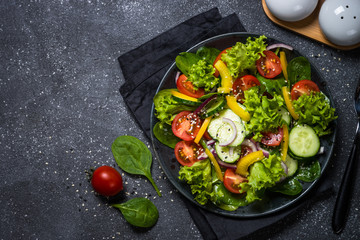 Fresh vegetables salad on black.