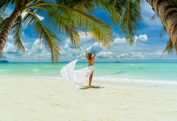 Woman enjoying her holidays on the tropical beach i