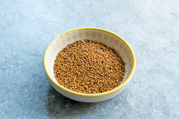 Yellow Mustard Seeds in Small Porcelain Bowl.