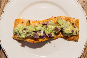 Salmon Fillet with Avocado in Plate at Dinner Table.
