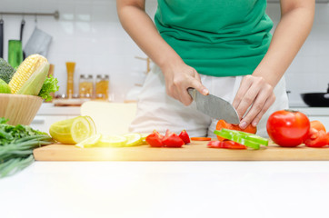 Diet. young pretty woman in green shirt cutting cooking and knife preparing fresh vegetables salad for good healthy in kitchen at home, healthy lifestyle, cooking, healthy food and dieting concept