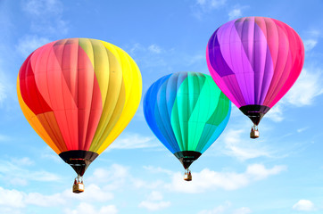 Colorful hot air balloon over bright sky with clouds.