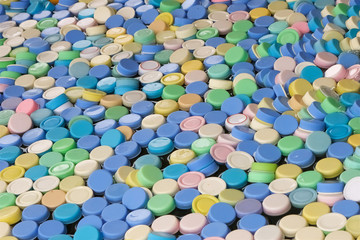 Fototapeta na wymiar many colored caps from plastic bottles