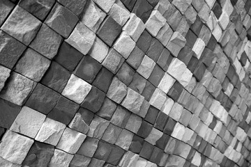 Black and white wall of wild stone in different colors lined with a pattern