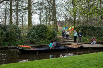 Fototapeta premium Flower garden, Netherlands , a group of people in a boat on a river