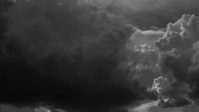 Great dramatic black and white cloudscape of huge heavy fluffy sunset clouds moving along sky. Time lapse of beautiful changes in windy heaven.