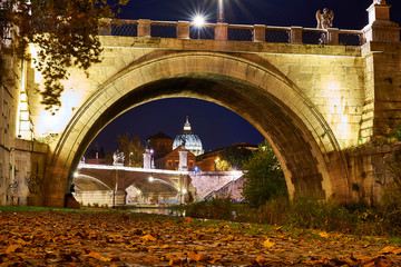 night view of the dome of st. peter's basilica under the bridge