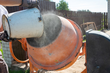 builder working with shovel during concrete cement solution mortar preparation. construction worker...