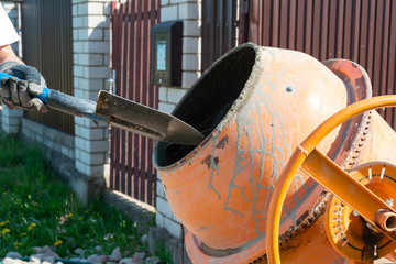 builder working with shovel during concrete cement solution mortar preparation. construction worker...
