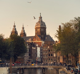 Fototapeta premium Holland, Amsterdam, July 25, 2018, the center is proud. People, streets, architecture, canals and bridges. The lifestyle of the locals. Pedestrians and cyclists. City traffic. Boats, flowers.