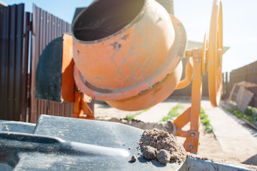 builder working with shovel during concrete cement solution mortar preparation. construction worker...