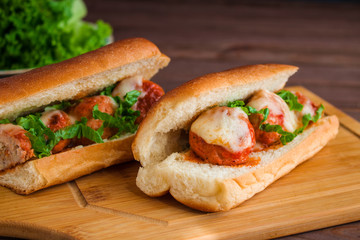homemade meatball sub sandwich with mozzarella on cutting board