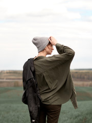 Stylish young woman posing in nature in street style clothing.