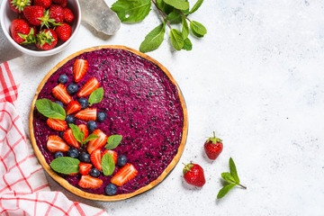 Berry cheesecake on white table top view.