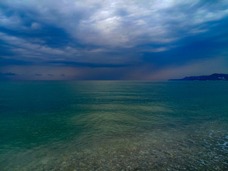 sea landscape is a pebbly beach with waves in white foam