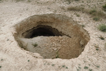 Trou dans le sol; plafond de grotte effondré. 