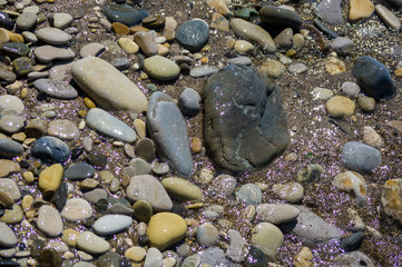 pebble stones on the sea beach, the rolling waves of the sea with foam