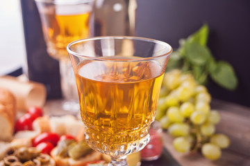 Italian bruschetta in assortment on the plate, glasses with white wine, grapes. Party or dinner concept.