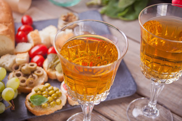 Italian bruschetta in assortment on the plate, glasses with white wine, grapes. Party or dinner concept.