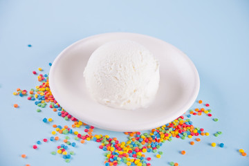 Vanilla ice cream with candy on the blue background