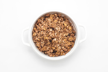 Bowl of muesli with oatmeal cereals and chocolate on white background. Healthy breakfast. Top view....