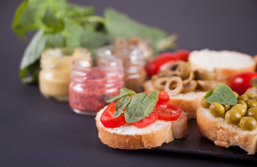 Italian bruschetta in assortment on the plate, set with small bottle of mustard