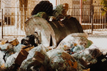 Fototapeta na wymiar A large pile of garbage packets is lying around the full trash tank. human waste. bad environmental impact