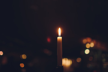 Candles Burning at Night. White Candles Burning in the Dark with focus on single candle in...