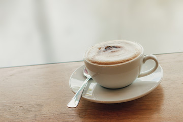 Cup of coffee cappuccino on wooden bar in cafe.