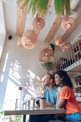 Happy couple is relaxing with gadgets in cafe