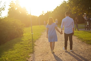 couple walking through grassy and green road