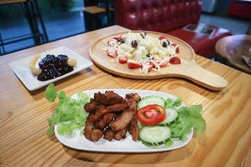 fruit salad, blueberry cheese cake and fried pork