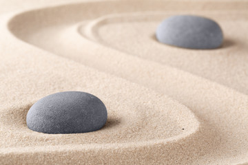 Fototapeta na wymiar Zen garden meditation stone. Round rock on sandy texture background. Yoga or mindfulness concept. .