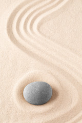 Fototapeta na wymiar Zen garden meditation stone. Round rock on sandy texture background. Yoga or mindfulness concept.