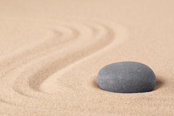Fototapeta na wymiar Japanese zen meditation garden with a round stone on sandy background with copy space. Concept for concentration focus and balance in life.