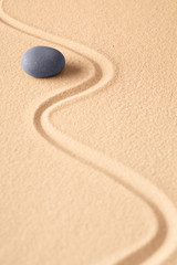 Fototapeta na wymiar Round zen meditation stone in Japanese buddhism sand garden. Concept for spirituality, harmony and purity? Focus point for concentration and relaxation.