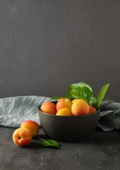 Tuinposter sweet delicious apricot on dark bowl grey table summer fresh fruit © Kufotos