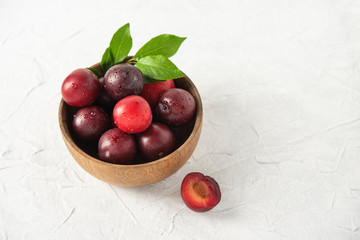 sweet fresh delicious red plums on bowl white wood table summer fruits