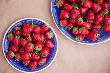Two bright blue plates with ripe strawberries. View from above. Healthy eating concept