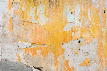 Old yellow concrete wall with cracked surface