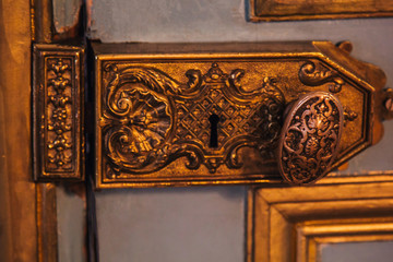 vintage door hinges painted patterns covered with gold leaf close-up. luxury fittings in the interior