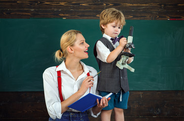 Education university and school system in The United States of America. Tutor teacher giving private lessons to preschool boy. Teacher talking at lesson. Back to school. - obrazy, fototapety, plakaty