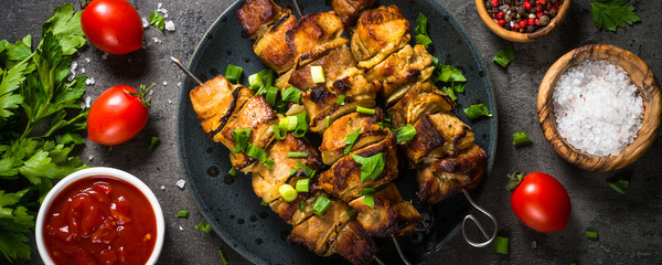 Grilled meat with herbs on black top view.