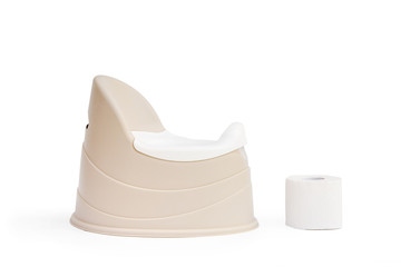 Children's pot beige with removable bowl stands on a light background and next to a roll of toilet paper