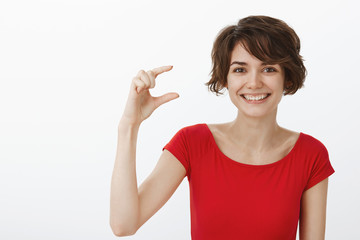 Cheerful happy cute young lucky woman short pixie haircut red t-shirt smiling broadly delighted...