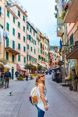 Beautiful young woman enjoying the view of Manarola in the UNESCO World Heritage Site Cinque Terre, Liguria, Italy